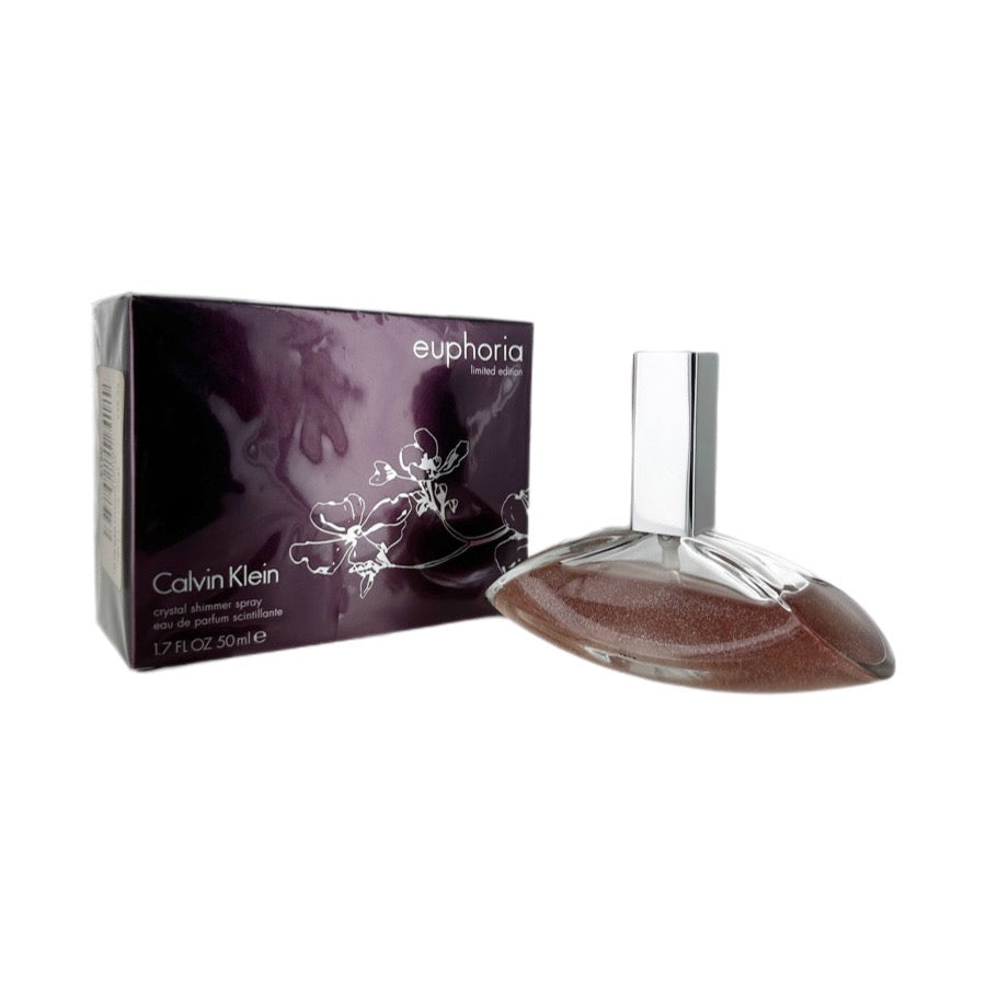 A bottle of Calvin Klein Euphoria Crystalline Eau de Parfum Spray, with its packaging box. The bottle is clear, showcasing the brown fragrance liquid inside, and the packaging is purple with floral designs.
