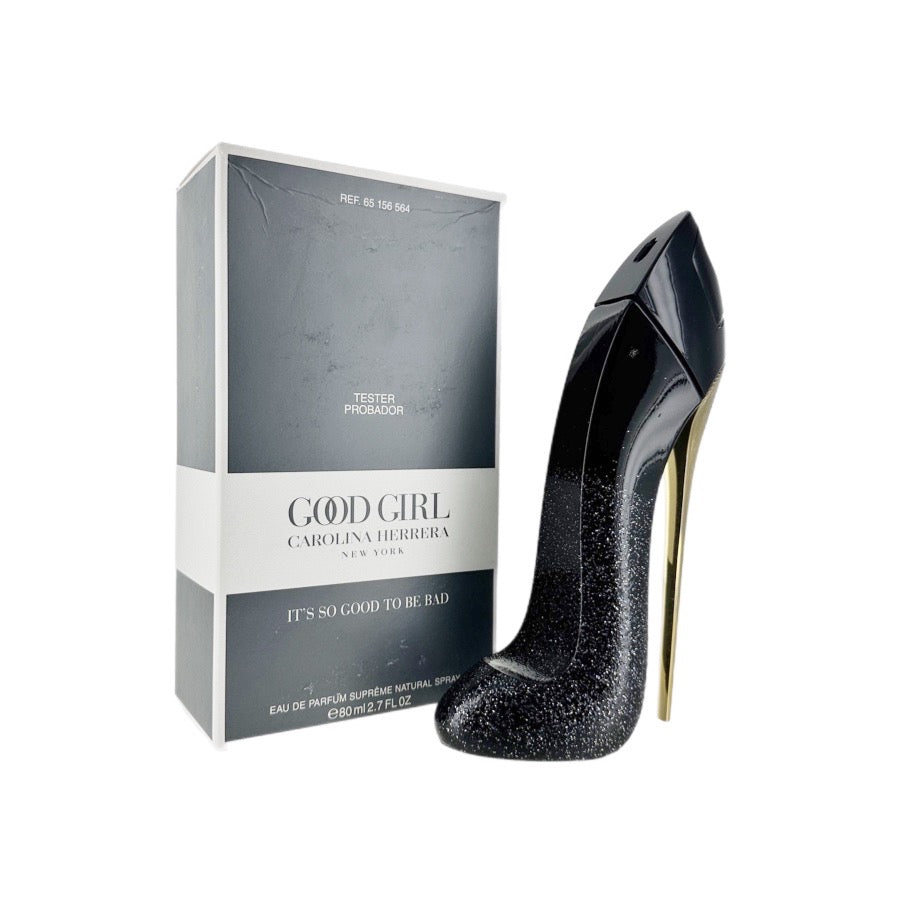 A tester package and a bottle of 'Good Girl Supreme' eau de parfum spray for women by Carolina Herrera, showing the product's packaging and the high heel shoe that is part of the product's imagery.