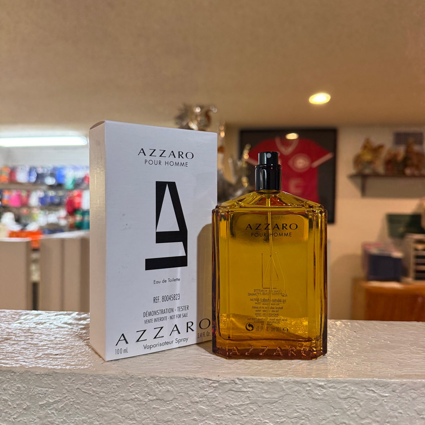 Azzaro Pour Homme perfume bottle and packaging on a table with a blurred background