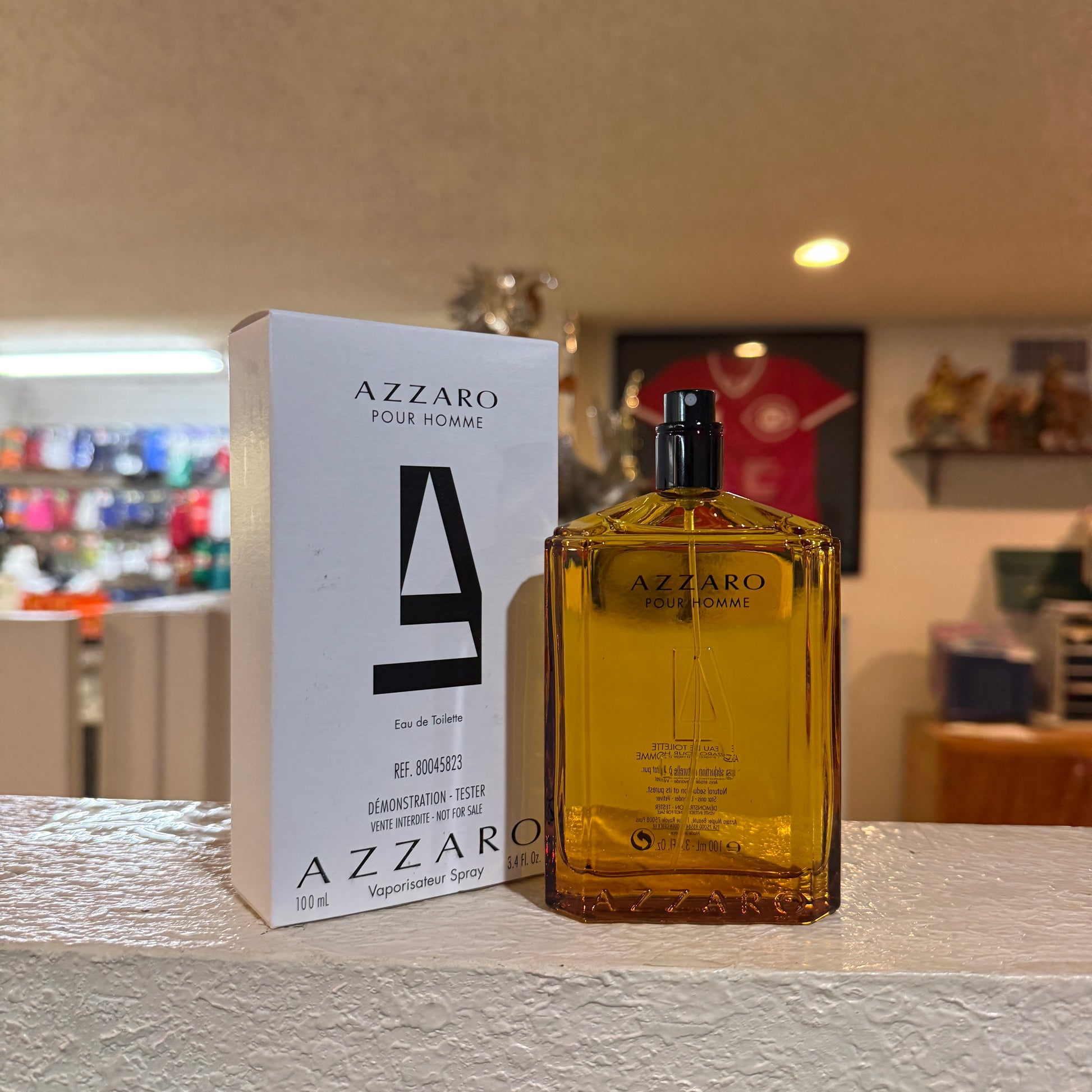Azzaro Pour Homme perfume bottle and packaging on a table with a blurred background