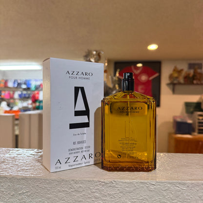 Azzaro Pour Homme perfume bottle and packaging on a table with a blurred background
