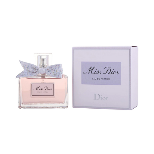A bottle of Miss Dior EDP with a pink label and a bow, alongside its purple box packaging with the Christian Dior logo.