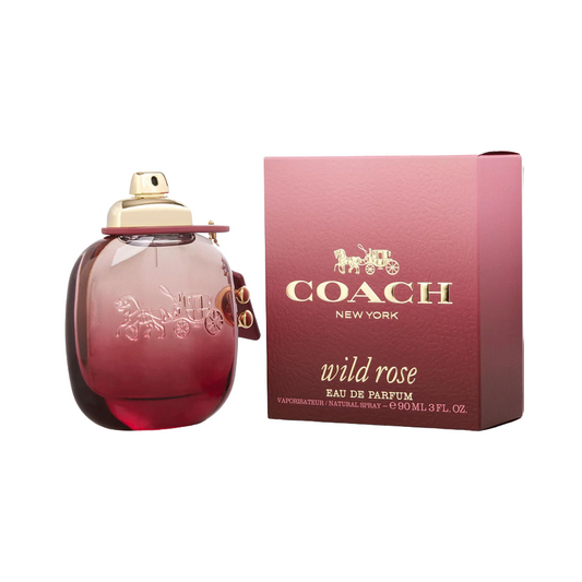 A bottle of Coach Wild Rose EDP with a gold-colored cap and a pink label, accompanied by a pink box with gold Coach branding and 'Wild Rose' text.