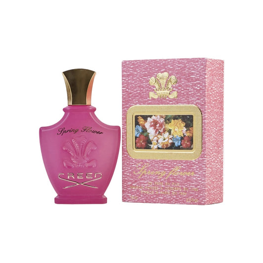A pink bottle of Creed Spring Flower Eau de Parfum Spray with a gold cap, accompanied by a pink and gold box with a floral design.