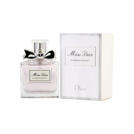 A bottle of Miss Dior Blooming Bouquet eau de toilette for women, accompanied by its packaging box. The bottle is clear, showcasing the light pink fragrance inside, and has a silver cap and bow.